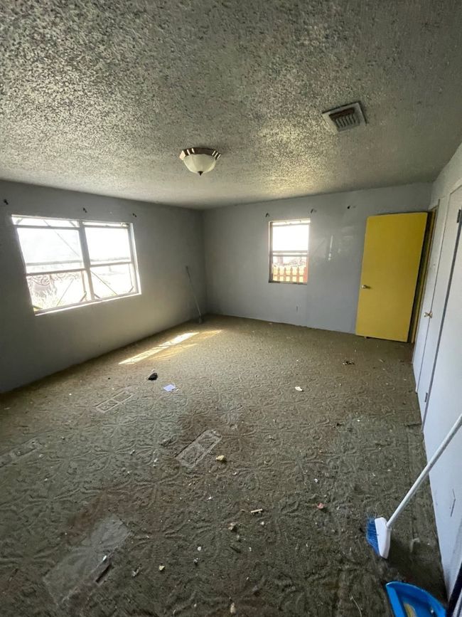 Unfurnished room featuring a textured ceiling, a wealth of natural light, and visible vents | Image 4