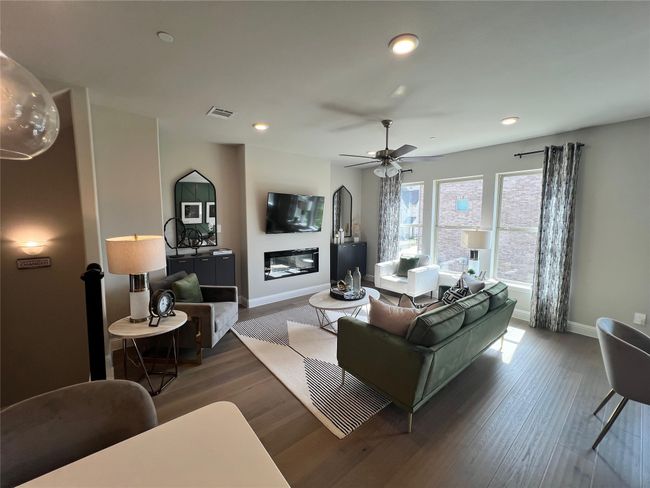 Living area featuring wood finished floors, recessed lighting, ceiling fan, and a glass covered fireplace | Image 8