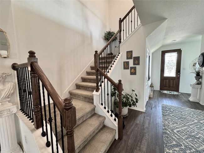 Entrance foyer featuring hardwood / wood-style flooring, stairway, and a textured ceiling | Image 22