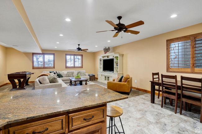 Kitchen featuring light stone countertops, baseboards, brown cabinetry, and recessed lighting | Image 32