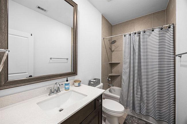 Secondary bathroom with custom mirror, tub/shower combo and chrome finishes. | Image 44