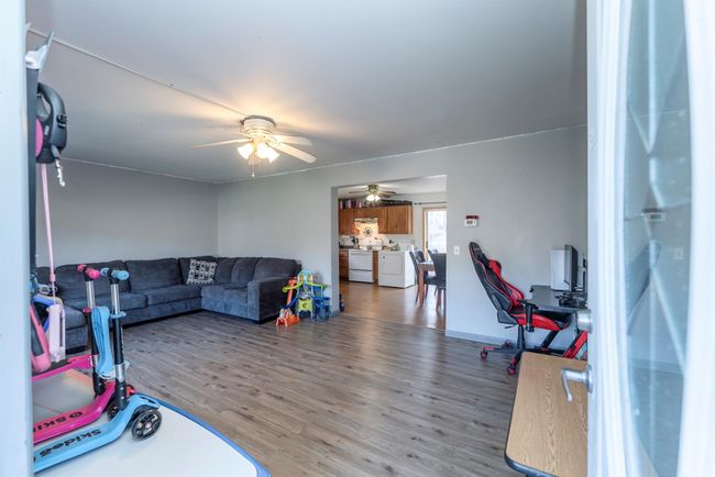 Living room with washer and dryer, wood finished floors, and ceiling fan | Image 20