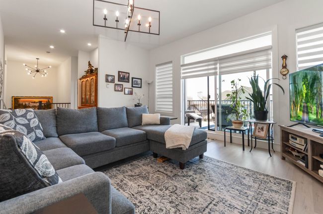 Living room featuring a chandelier, light wood-style floors, and recessed lighting | Image 6