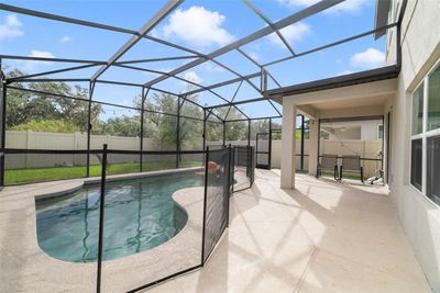 Relax poolside under the covered lanai overlooking the HEATED POOL or soak up the Vitamin D on the pool’s sun shelf, there is a safety fence for peace of mind and it’s all screened for maximum comfort. | Image 2