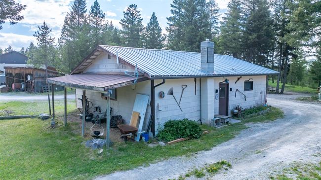 View of side of property with driveway, a chimney, and metal roof | Image 6