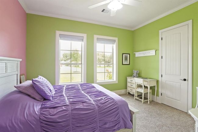 This Secondary Bedroom has all the same features as the previous bedroom, only this one includes two cased windows overlooking the lush Front Yard and grand oak tree. | Image 39