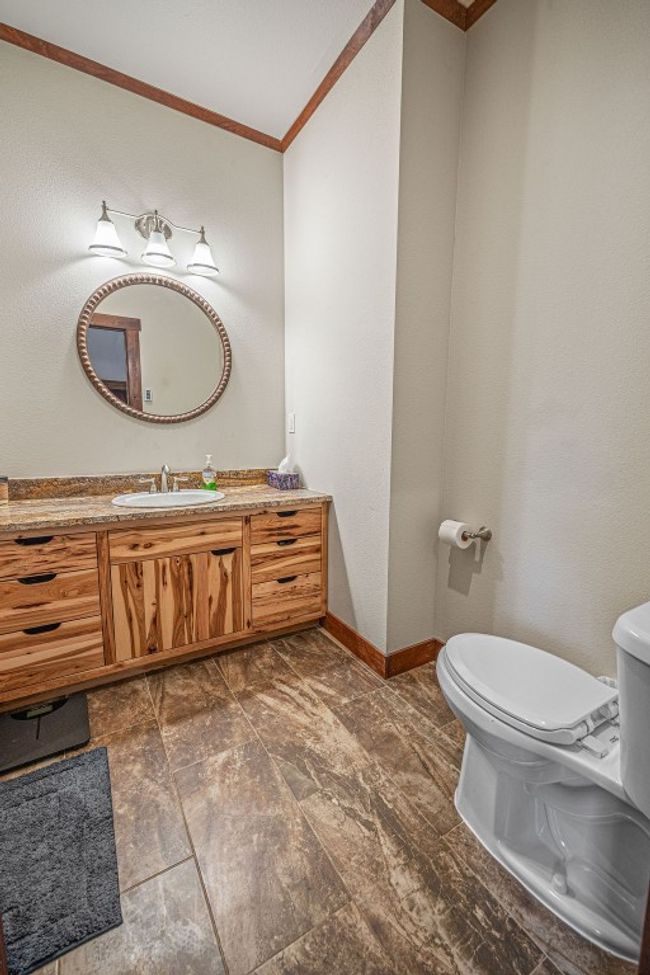 Half bathroom with baseboards, vanity, toilet, and crown molding | Image 25