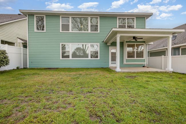 Back of property with a ceiling fan, a yard, fence, and a covered patio | Image 26