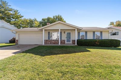 Single story home with covered porch, a front lawn, and a garage | Image 1