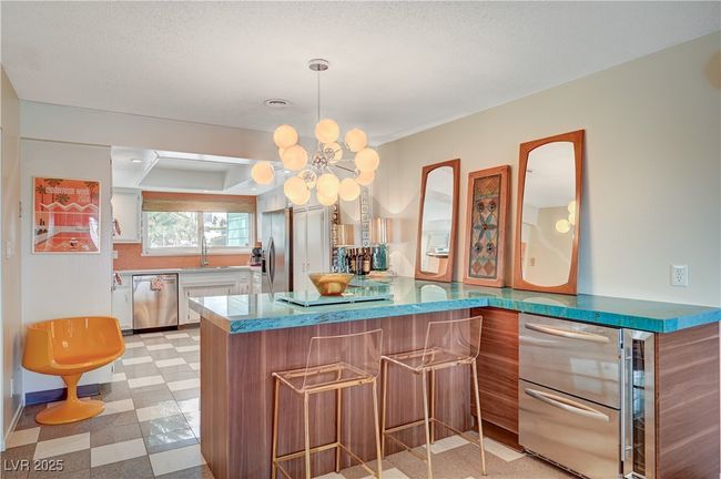 Bar with stainless steel appliances, light floors, and an inviting chandelier | Image 13