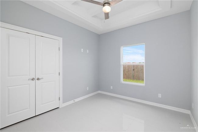Unfurnished bedroom with a closet, ceiling fan, and light tile patterned floors | Image 9