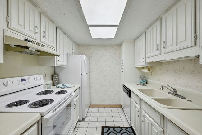 Well appointed galley style kitchen, with plenty of storage. Refrigerator included. | Image 7