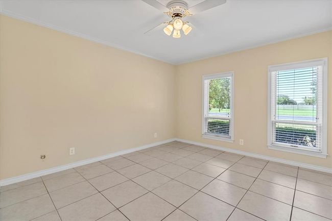 Empty room featuring crown molding, light tile patterned floors, and ceiling fan | Image 18