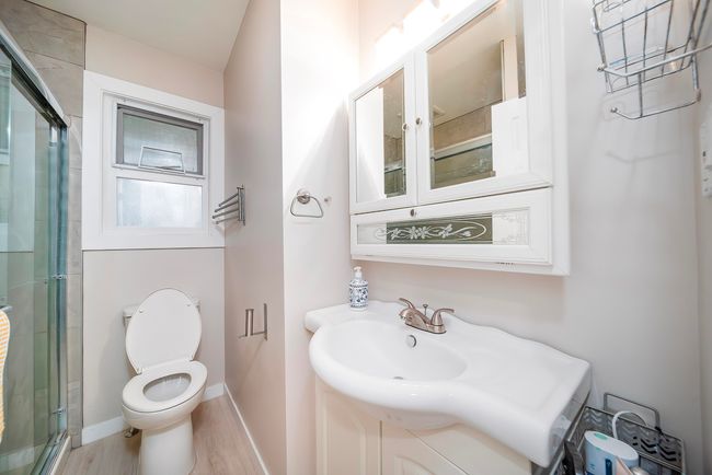 Full bathroom featuring baseboards, a shower with shower door, toilet, and wood finished floors | Image 13