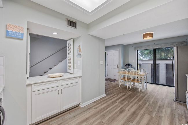 Dining area featuring light wood-type flooring, stairs, and baseboards | Image 8