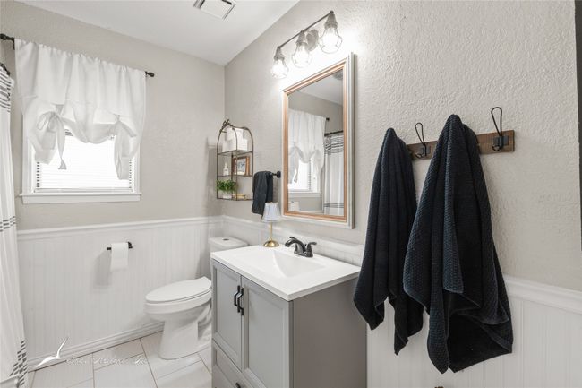 Bathroom featuring a wainscoted wall, vanity, toilet, and visible vents | Image 19
