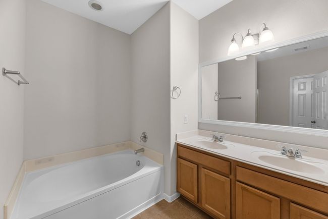 The en-suite bathroom offers a spa-like atmosphere with its elegant design, high end finishes, and tasteful lighting, creating a retreat within your own home. | Image 19