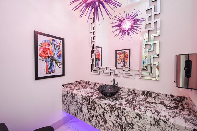Showstopper half bathroom features Cold Spring granite countertops, stunning light fixture, ambient lighting, vessel sink, and free floating vanity. | Image 41