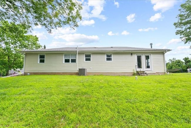 Rear view of house featuring a lawn, central AC unit, and entry steps | Image 63