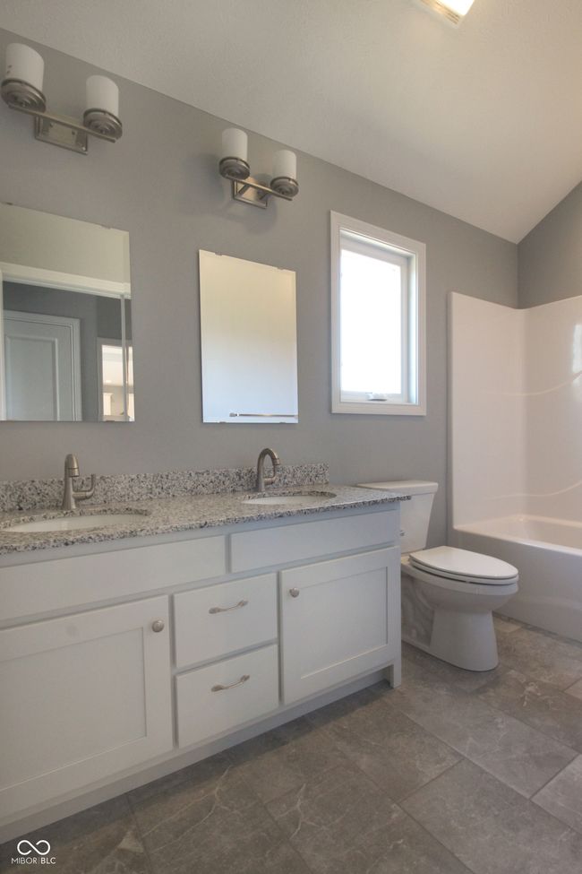 full bath with toilet, double vanity, and a sink | Image 13