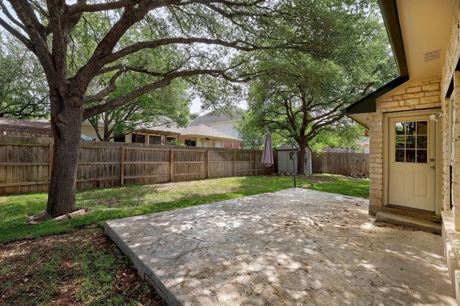 View of yard with a patio, a fenced backyard, an outbuilding, and a storage unit | Image 32