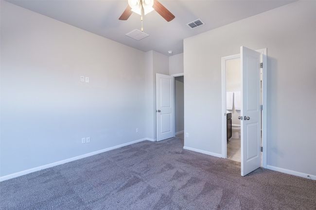 Unfurnished bedroom featuring baseboards, visible vents, carpet floors, ceiling fan, and connected bathroom | Image 26