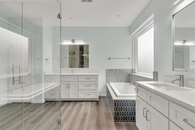 Full bath with a garden tub, wood finished floors, a sink, a stall shower, and two vanities | Image 29