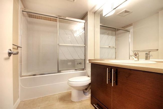 Bathroom featuring vanity, shower / bath combination with glass door, toilet, tile patterned flooring, and visible vents | Image 21