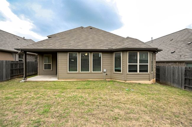 Rear view of house with a fenced backyard, a yard, and a patio area | Image 7