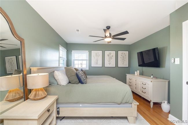 Bedroom with baseboards, light wood-style flooring, visible vents, and a ceiling fan | Image 27