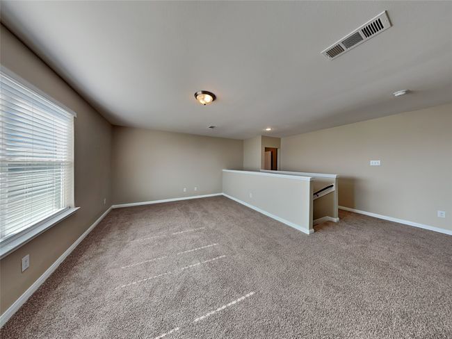 Carpeted spare room featuring baseboards and a smoke detector | Image 10