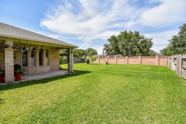 Stretching out behind the home is a generously sized, fenced backyard—lush with green grass and ready for outdoor fun, pets, or future enhancements like a garden or pool. | Image 27