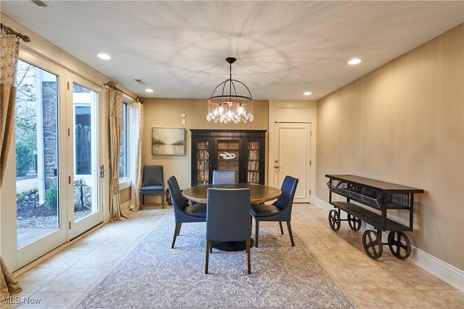 An extra room to the right of the lower level kitchen is set up as dining/ card table space. This is a great multi purpose room and also walks out to the patio, yard and pool area. | Image 35