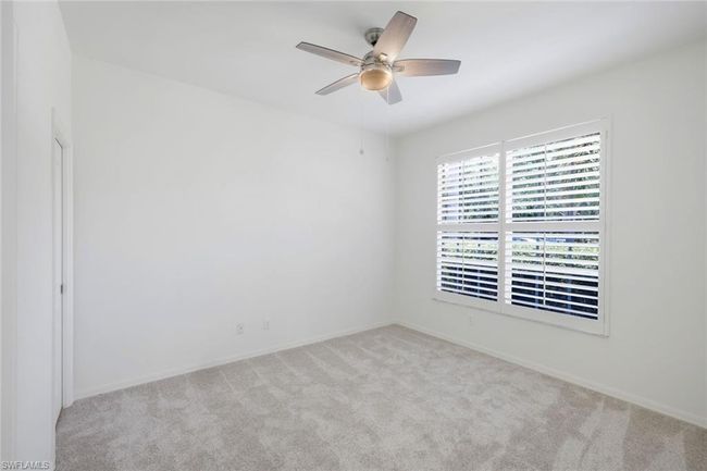 Carpeted room with ceiling fan and baseboards | Image 14