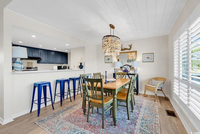 Dining area featuring light wood-style floors, baseboards, a notable chandelier, and visible vents | Image 8