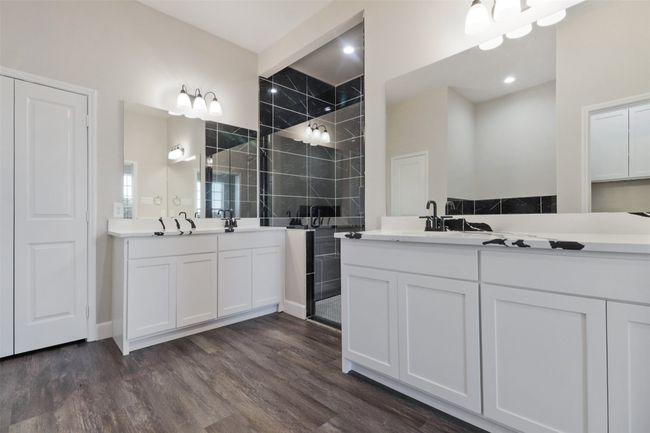 Full bathroom featuring two vanities, a sink, walk in shower, and wood finished floors | Image 12