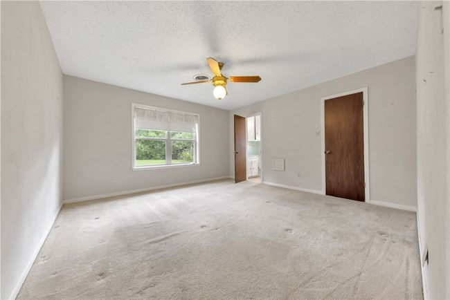 Carpeted empty room with a textured ceiling and a ceiling fan | Image 11