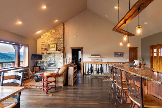 Living room featuring high vaulted ceiling, dark wood-style flooring, healthy amount of natural light, a stone fireplace, and recessed lighting | Image 6