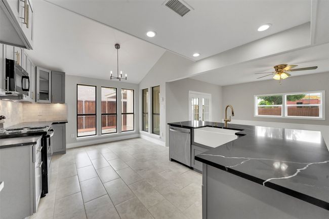 Kitchen featuring appliances with stainless steel finishes, recessed lighting, backsplash, gray cabinetry, and a chandelier | Image 9