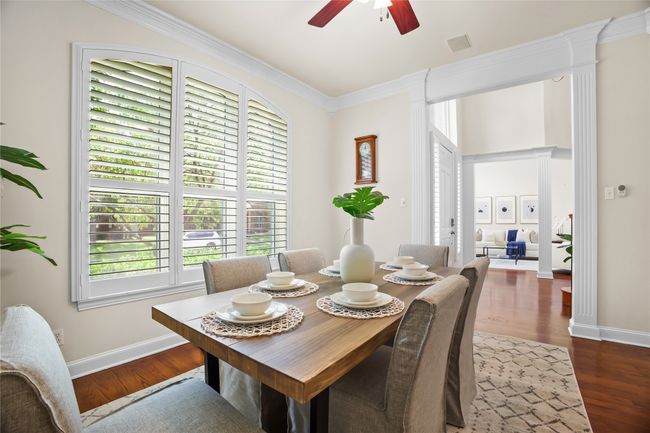 Dining room with crown molding, ceiling fan, and wood finished floors | Image 6