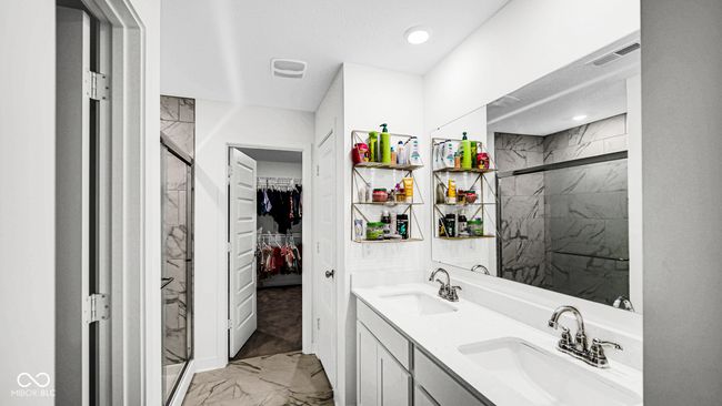 bathroom with marble finish floors, a marble finish shower, double vanity, a spacious closet, and recessed lighting | Image 32