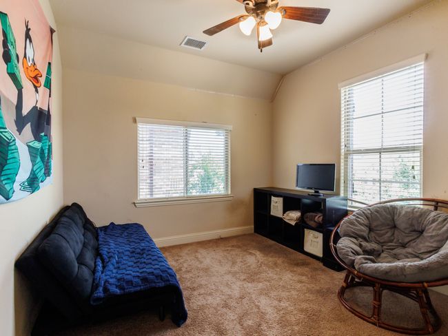 Another nice-sized bedroom with multiple windows and a ceiling fan. | Image 27