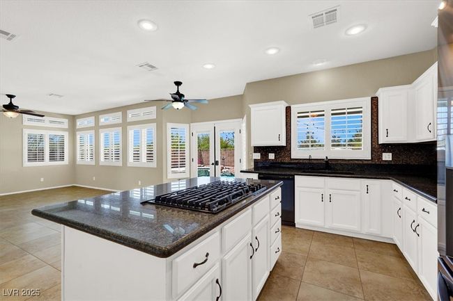 Kitchen with gas stovetop, a ceiling fan, black dishwasher, light tile patterned floors, and recessed lighting | Image 14