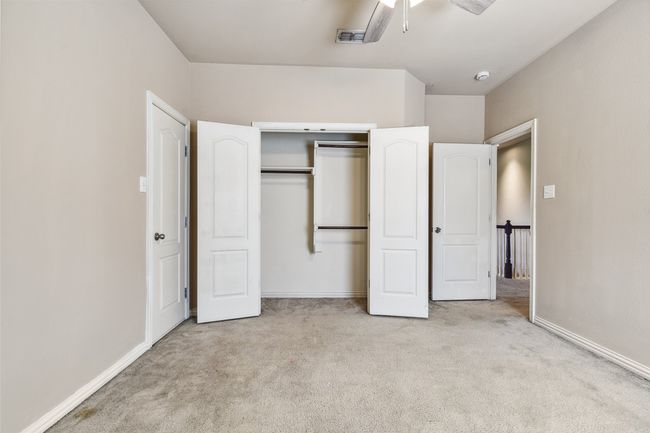 Unfurnished bedroom with carpet, a closet, baseboards, and ceiling fan | Image 20