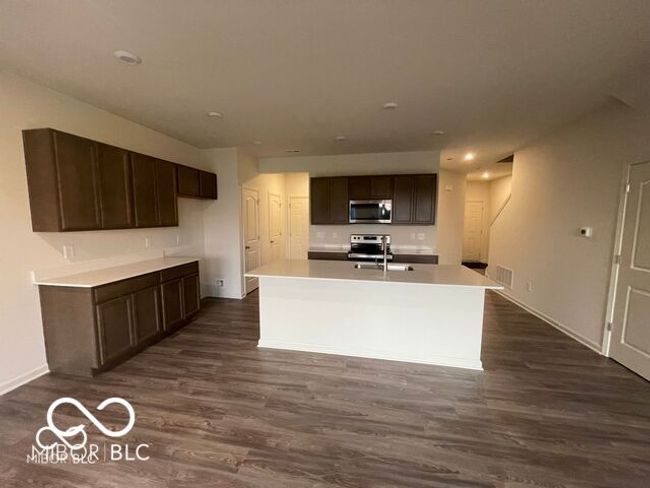 kitchen with appliances with stainless steel finishes, baseboards, dark wood-style floors, and visible vents | Image 4