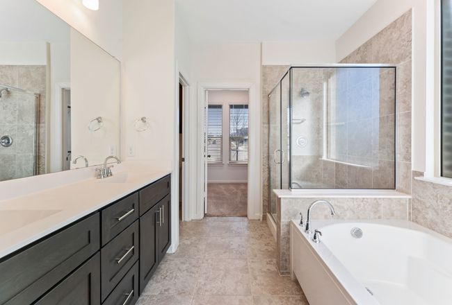 Bathroom featuring a sink, a garden tub, a stall shower, and double vanity | Image 9