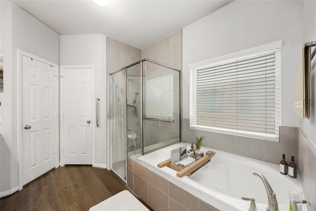 This additional view of the primary bath showcases a walk-in shower with tile surround and a separate garden tub perfect for soaking after a long day. *Virtually Staged | Image 15