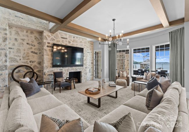 The lake-level family room looks out to the pool, lake, and green space. | Image 36
