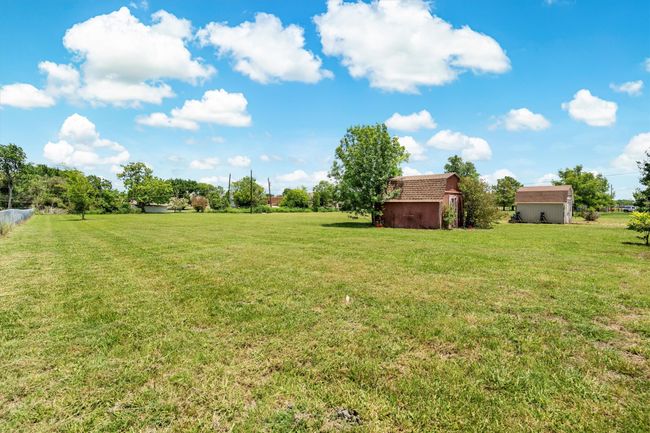 View of large lot area behind fenced yard | Image 29