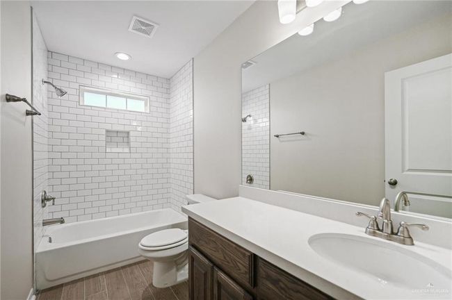 Bathroom featuring vanity, shower / bath combination, and wood finished floors | Image 9